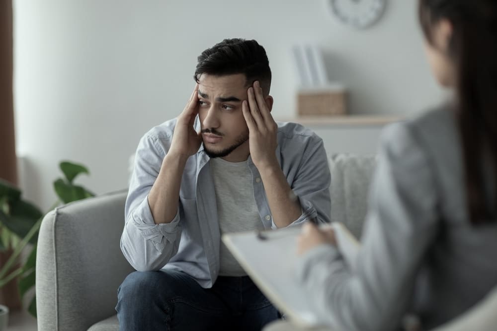 What Is Alcohol Addiction and How Is It Defined? 1 Adult male talking to a therapist about alcohol addiction